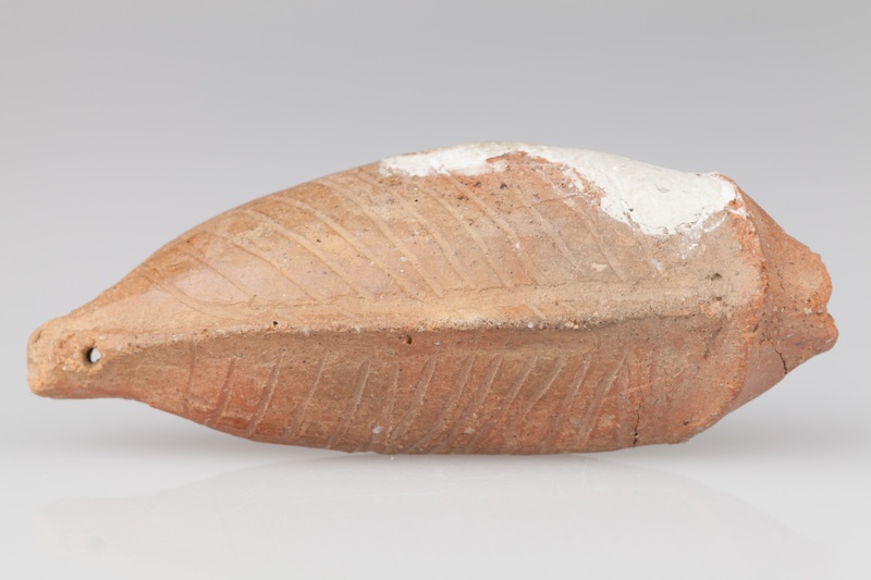 Grzechotka ornitomorficzna zdobiona ornamentem rytym.