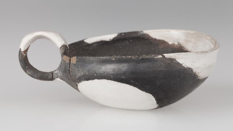 Czerpak o wklęsłym dnie, półkolistym brzuścu, brzegu zaokrąglonym do środka. Wnętrze zdobione odciskiem koła i skośnymi rowkami