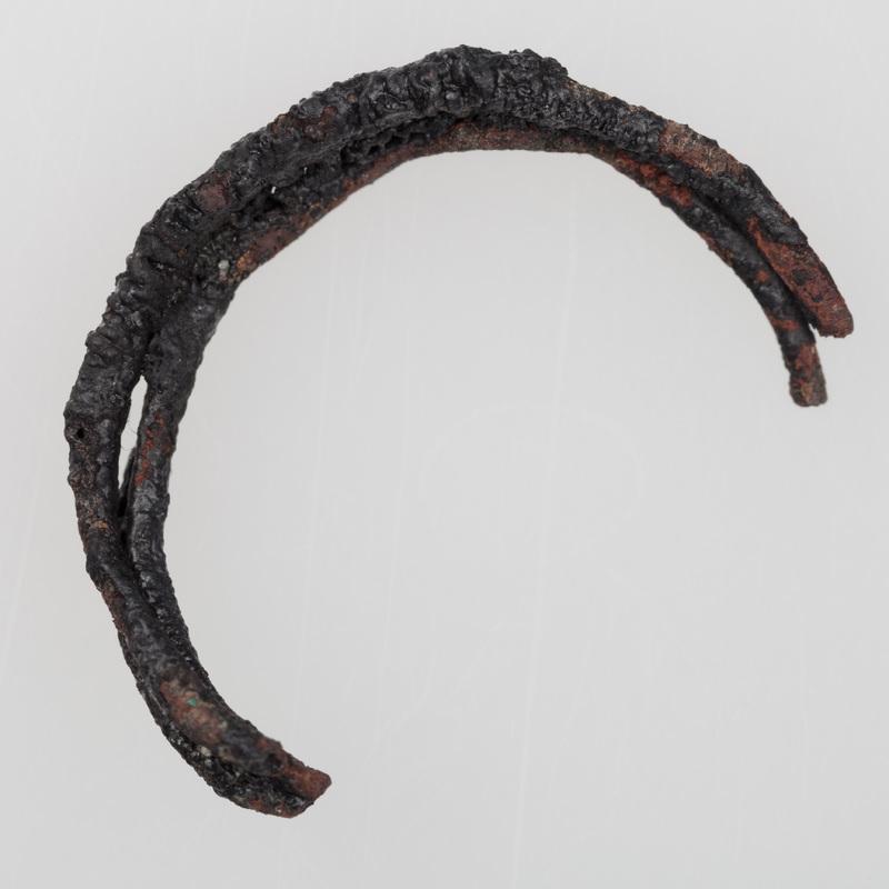 Fragmenty ozdób wykonanych z brązu, przepalonych na stosie, w tym skręt i szpila