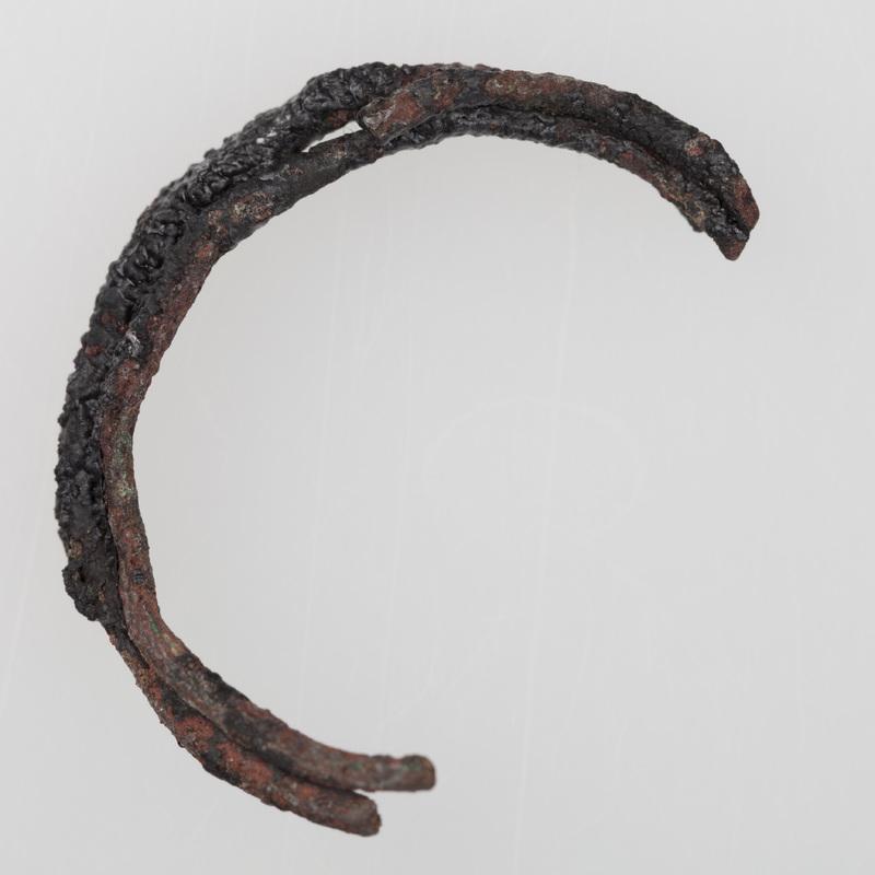 Fragmenty ozdób wykonanych z brązu, przepalonych na stosie, w tym skręt i szpila