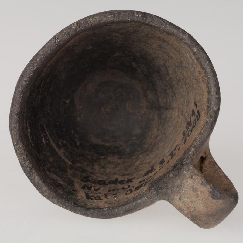 Czerpak o płaskim dnie, brzuścu stożkowatym i taśmowatym uchu