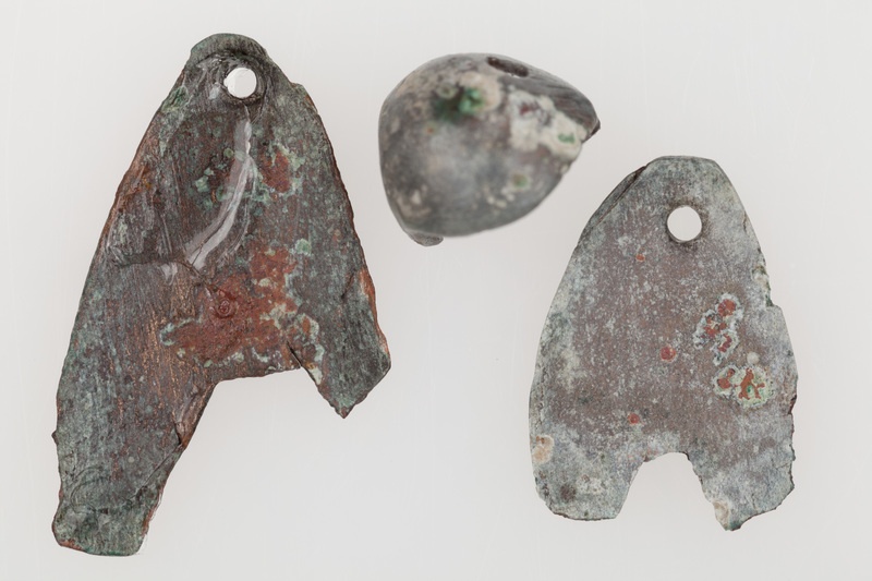 Dwie sercowate zawieszki wykonane z cienkiej blachy brązowej, zaopatrzone w dwa otwory