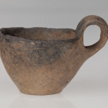 Czerpak o płaskim dnie, brzuścu stożkowatym i taśmowatym uchu