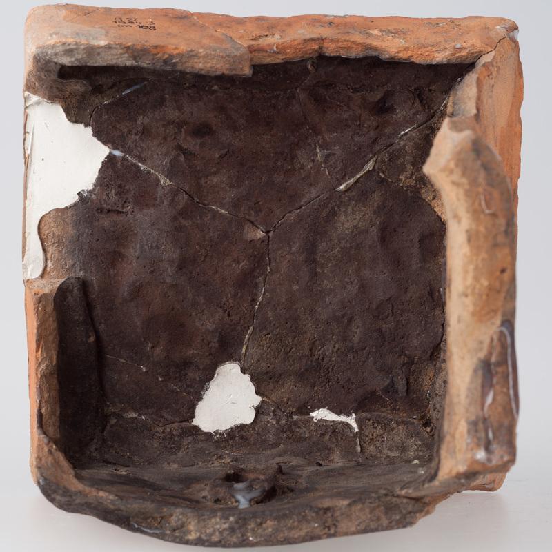 Kafel z postacią kobiety w arkadzie zamku z okrągłym przedmiotem w dłoni