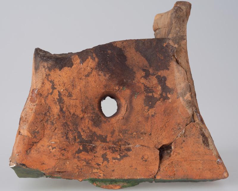 Kafel z postacią kobiety w arkadzie zamku z okrągłym przedmiotem w dłoni