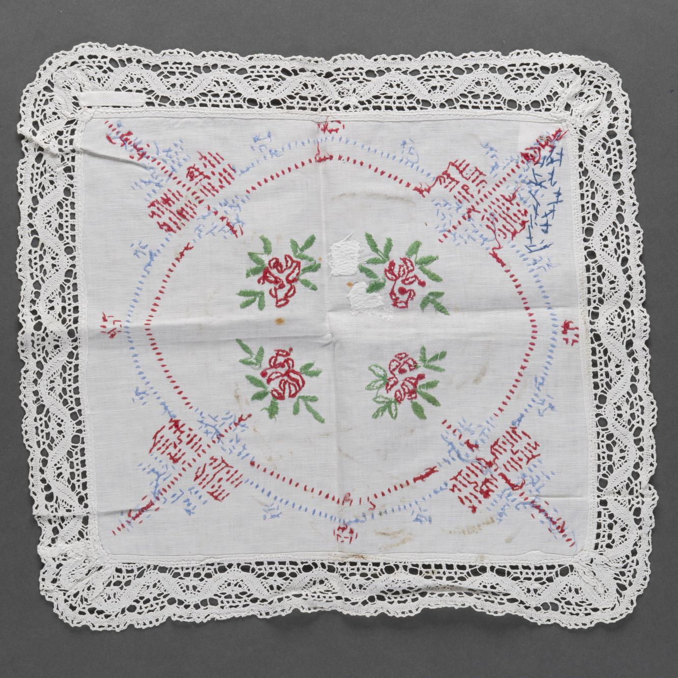 Serwetka biała z kolorowym haftem, obszyta koronką